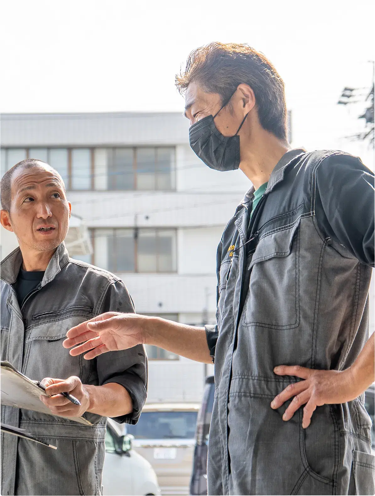 車のそばで打ち合わせをする社員
